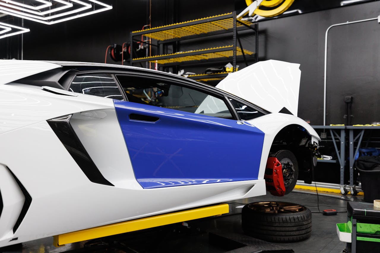 A luxury sports car being serviced inside a modern auto repair shop.